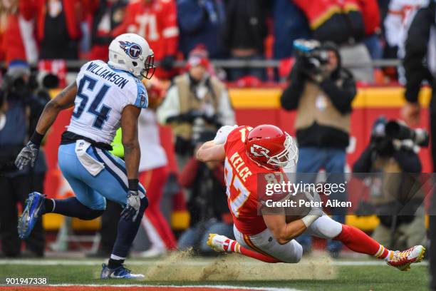 Tight end Travis Kelce of the Kansas City Chiefs loses his footing while making a touchdown catch in front of inside linebacker Avery Williamson of...