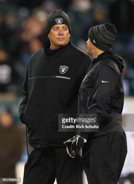 Head coach Jack Del Rio, left, of the Oakland Raiders talks with a coach before a game against the Philadelphia Eagles at Lincoln Financial Field on...