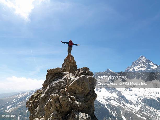 mountaineer stands on top of pinnacle, mtns below - en la cima del mundo fotografías e imágenes de stock