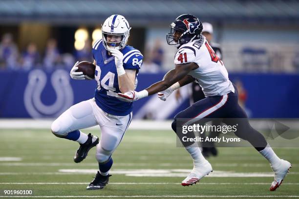 Jack Doyle of the Indianapolis Colts runs with the ball chased by Zach Cunningham of the Houston Texans during the first half at Lucas Oil Stadium on...