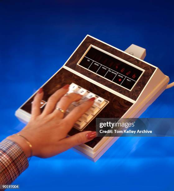 Woman's hand enters numbers into of one of the machines from the TRW company's 2001 System, a line of electronic point-of-sale buisness machines,...