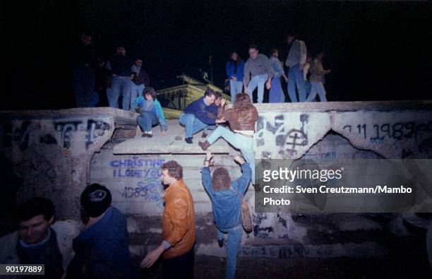 Germans from East- and West germany climb on the Berlin wall, on February 19 in West Berlin, Germany. East Germany began to dismantle the wall on...