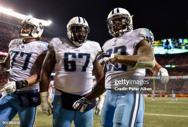 Running back Derrick Henry of the Tennessee Titans celebrates with teammates offensive tackle Taylor Lewan and offensive guard Quinton Spain after...