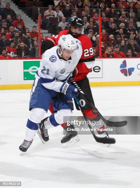 Johnny Oduya of the Ottawa Senators battles for puck possession against Brayden Point of the Tampa Bay Lightning at Canadian Tire Centre on January...