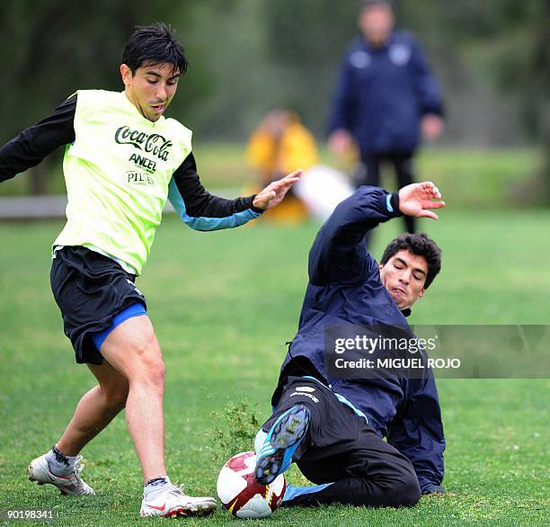 Uruguayan footballers Jorge Fucile and Luis Suarez vie for the ball during a training session on Agost 31, 2009 in Montevideo. Uruguay will face Peru...