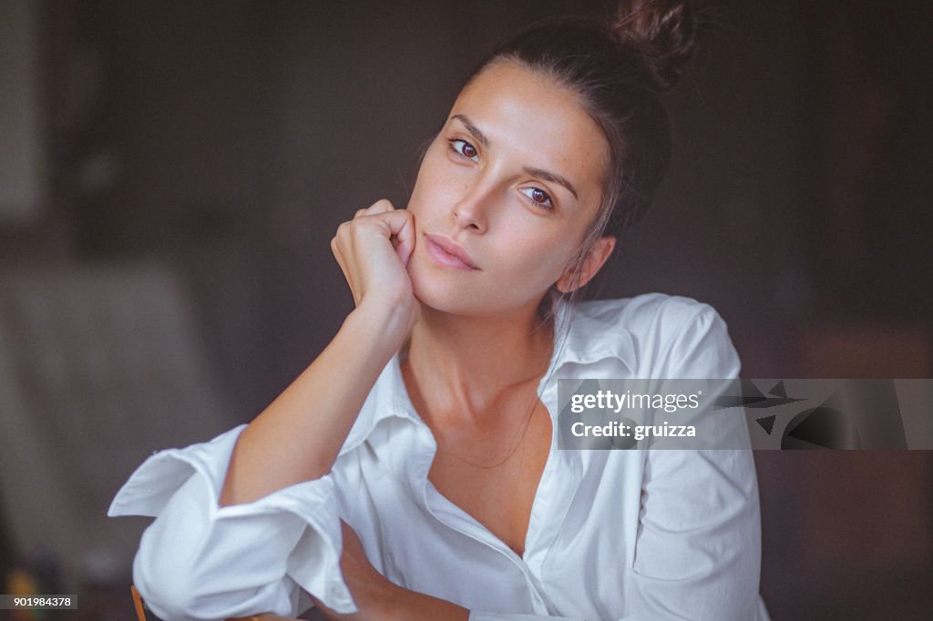 Porträt einer nachdenklichen jungen Frau in weißem Hemd