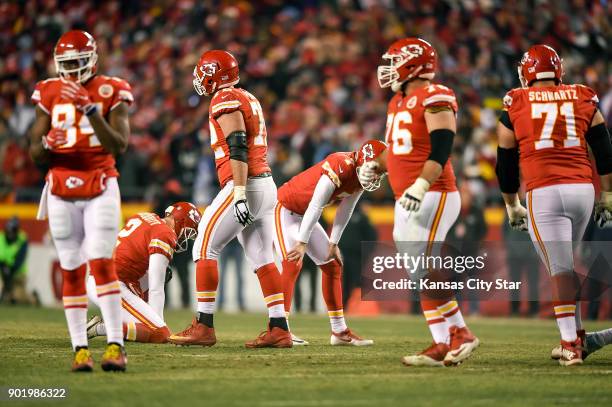Kansas City Chiefs kicker Harrison Butker reacts with holder Dustin Colquitt after Butker's 48-yard field goal in the third quarter bounced off the...