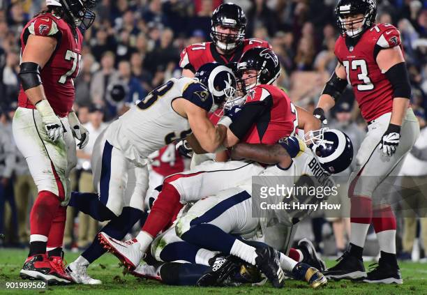 Quarterback Matt Ryan of the Atlanta Falcons sacked by outside linebacker Connor Barwin and nose tackle Michael Brockers of the Los Angeles Rams...