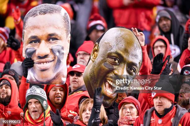 Fans hold up large head photos of Kansas City Chiefs cornerback Marcus Peters and Kansas City Chiefs outside linebacker Justin Houston during play...