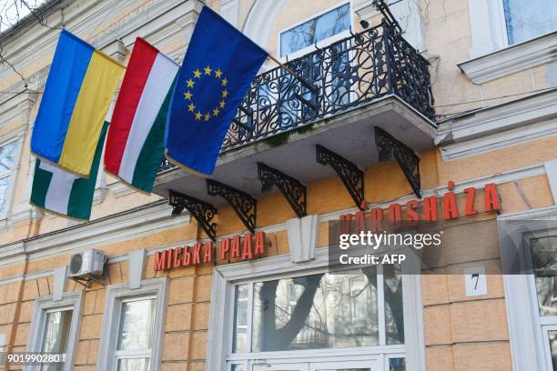 Picture taken on November 15, 2017 shows flags of EU, Hungary, Ukraine, Beregove and inscriptions in two languages, Ukrainian and Hungarian, on a...