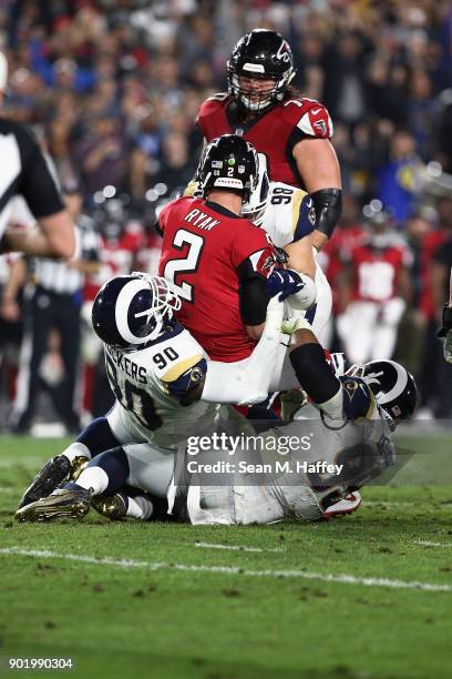 Matt Ryan of the Atlanta Falcons is sacked by Connor Barwin of the Los Angeles Rams and Michael Brockers of the Los Angeles Rams during the second...