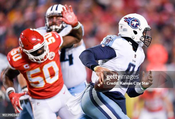 Tennessee Titans quarterback Marcus Mariota breaks out of the pocket as Kansas City Chiefs outside linebacker Justin Houston appears to be blocked in...