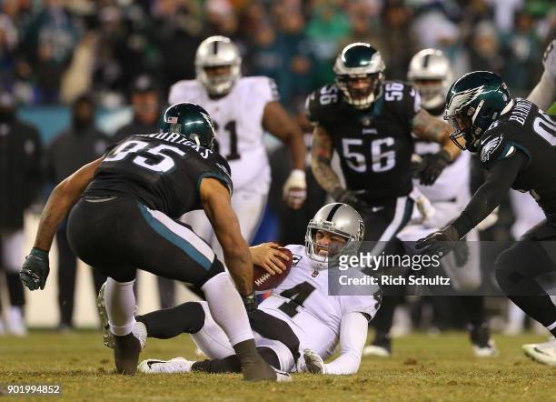 Quarterback Derek Carr of the Oakland Raiders slides after a small gain as Mychal Kendricks of the Philadelphia Eagles closes in during the fourth...