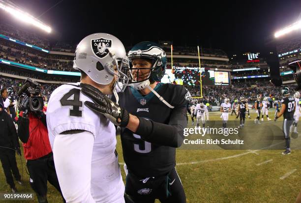 Quarterback Nick Foles of the Philadelphia Eagles meets with quarterback Derek Carr of the Oakland Raiders after the Eagles defeated the raiders...