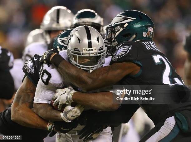 Jalen Richard of the Oakland Raiders is grabbed by Rodney McLeod and Malcolm Jenkins of the Philadelphia Eagles during the fourth quarter of a game...