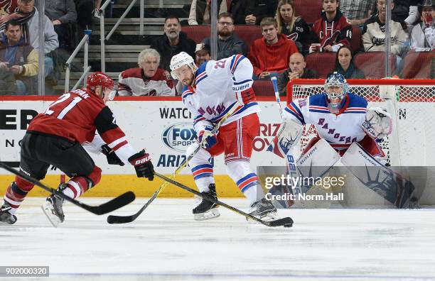 Kevin Shatenkirk of the New York Rangers defends as Derek Stepan of the Arizona Coyotes skates the puck in on goalie Henrik Lundqvist of the Rangers...