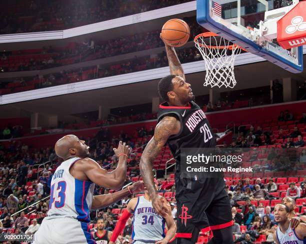 Tarik Black of the Houston Rockets \dunks the ball in front of Anthony Tolliver of the Detroit Pistons during the an NBA game at Little Caesars Arena...