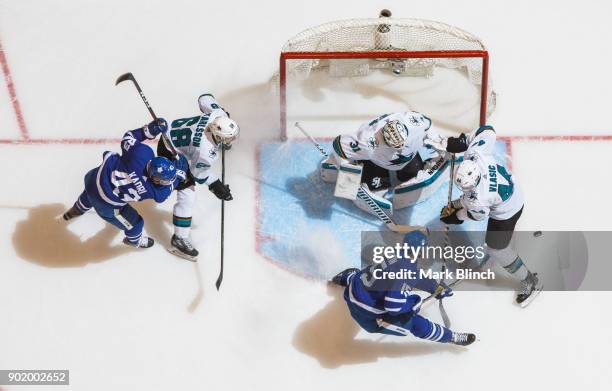 Matt Martin and Nazem Kadri of the Toronto Maple Leafs go to the net against Martin Jones, Marc-Edouard Vlasic, and Melker Karlsson of the San Jose...