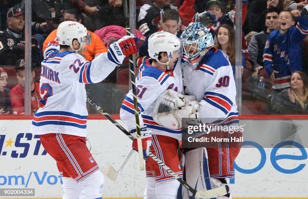 Goalie Henrik Lundqvist of the New York Rangers celebrates with teammates David Desharnais and Kevin Shattenkirk after a 2-1 shootout victory against...