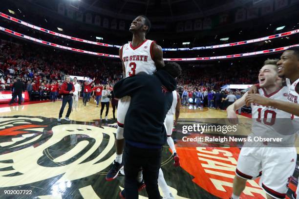 North Carolina State's Lavar Batts Jr. Jumps into the arms of Devon Daniels as they celebrate after a 96-85 victory against Duke at the PNC Arena in...