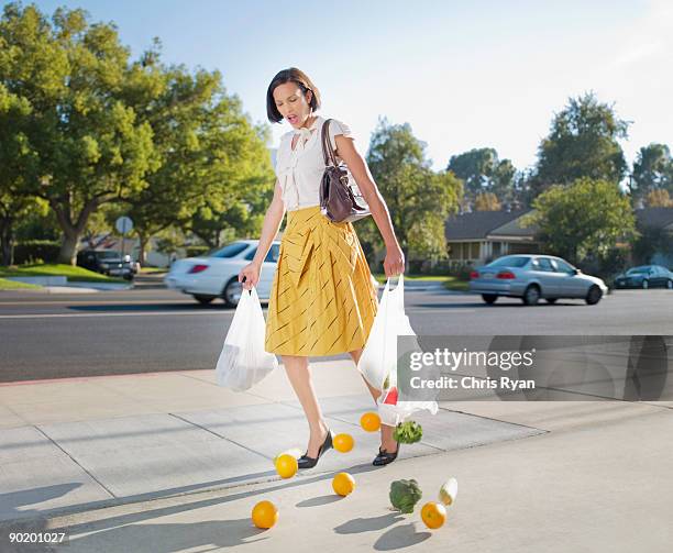 woman dropping groceries on sidewalk - fuss stock pictures, royalty-free photos & images