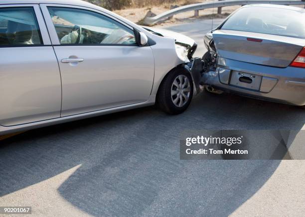 two cars in collision on roadway - car collision stock pictures, royalty-free photos & images