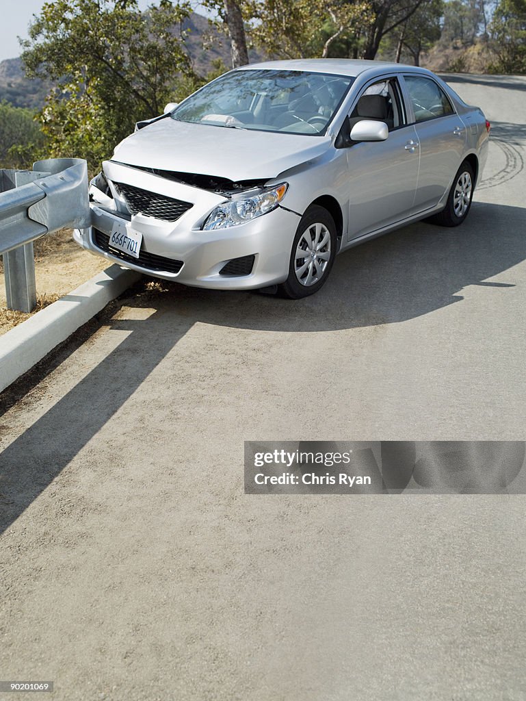 Wrecked Car on road guardrail