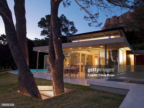 patio area and glass walls of modern home - garden lighting stock pictures, royalty-free photos & images