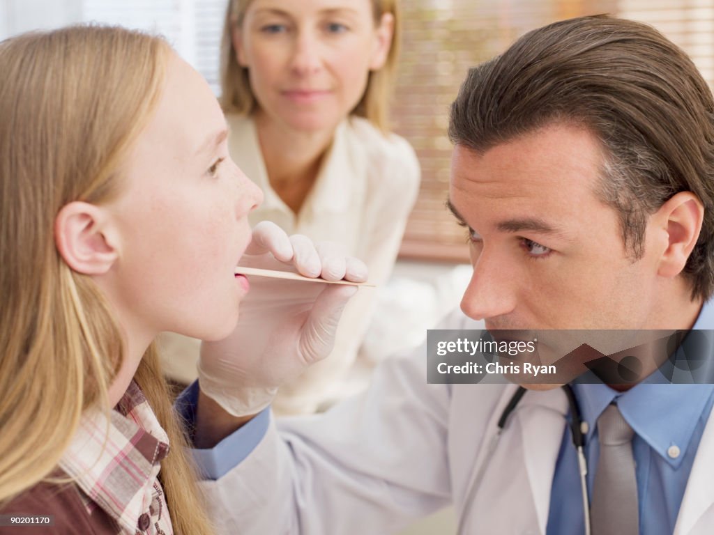 Médico examinar paciente enquanto mãe watches