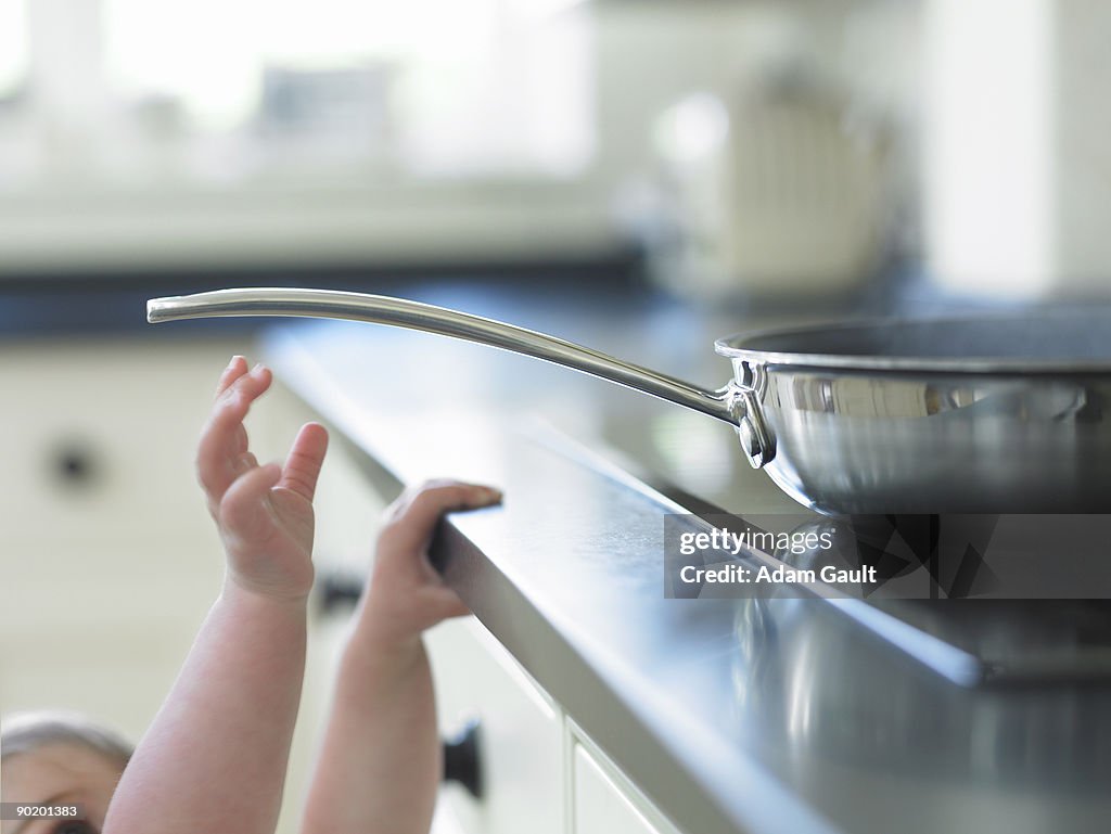 Baby reaching for hot frying pan on stove