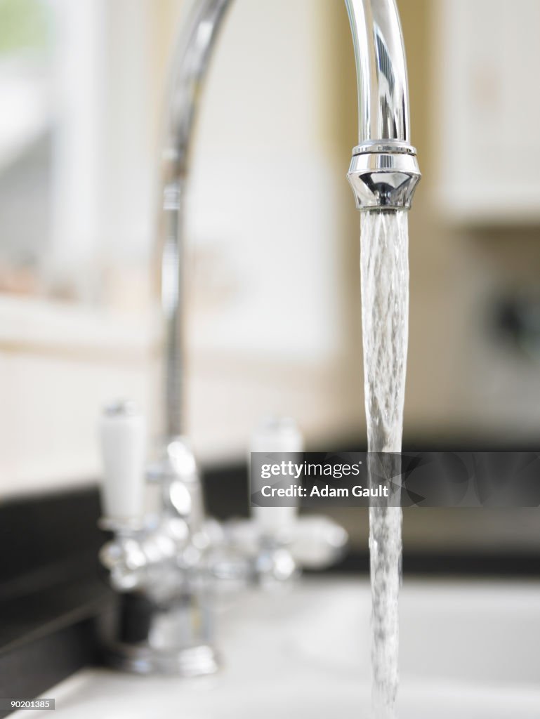 Close up of water pouring from kitchen faucet