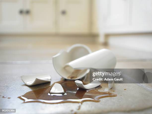 close up of broken coffee mug and spilled coffee - coffee spill fotografías e imágenes de stock