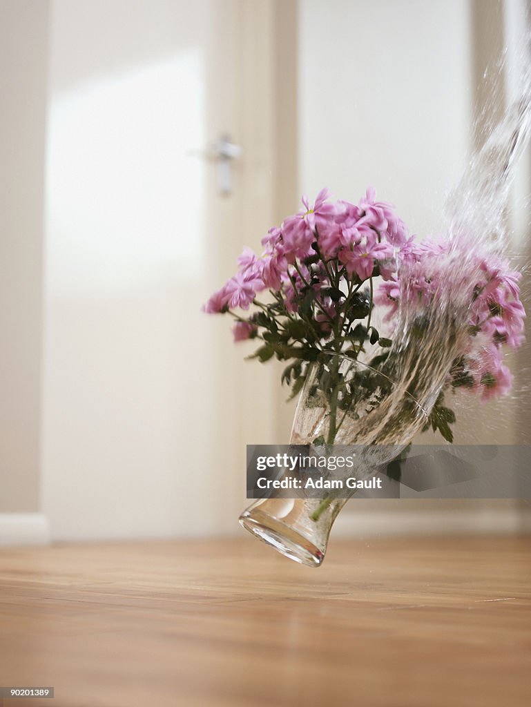 Vase of flowers falling on floor
