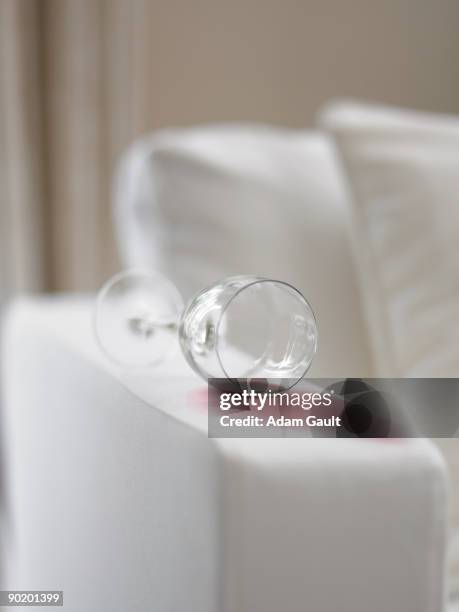 red wine spill staining sofa - knoeien stockfoto's en -beelden