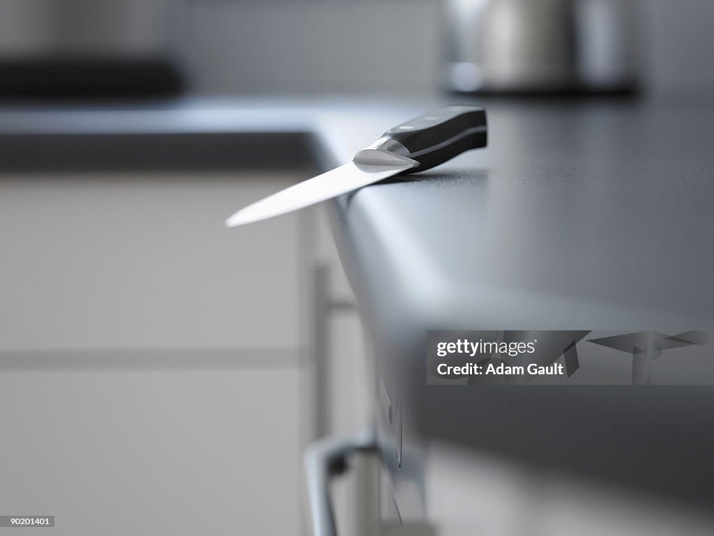 Close up of kitchen knife about to fall off counter