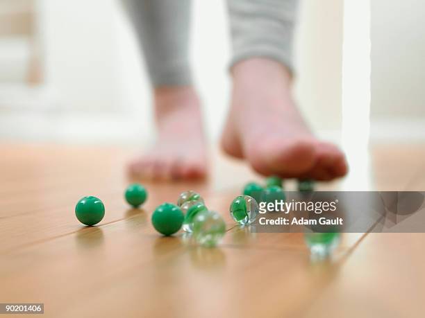 child about to slip on marbles on the floor - clumsy walker stock pictures, royalty-free photos & images