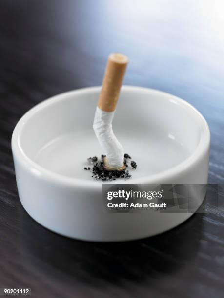 stubbed out cigarette in ashtray - aschenbecher stock-fotos und bilder