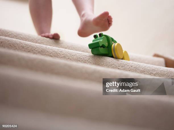 woman about to slip on toy left on staircase - stumble stock pictures, royalty-free photos & images