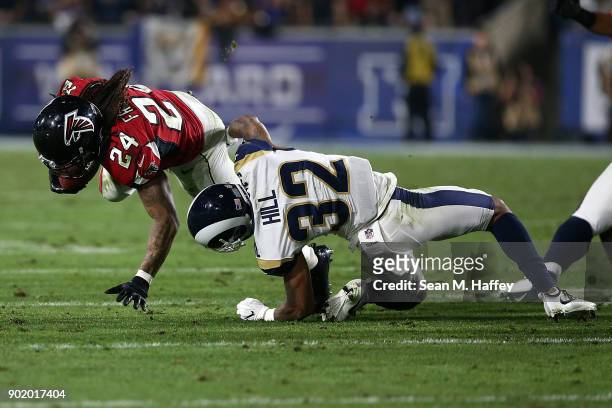 Devonta Freeman of the Atlanta Falcons breaks the tackle from Troy Hill of the Los Angeles Rams during the NFC Wild Card Playoff Game at the Los...