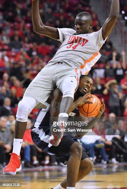 Cheikh Mbacke Diong of the UNLV Rebels lands on DeAngelo Isby of the Utah State Aggies during their game at the Thomas & Mack Center on January 6,...