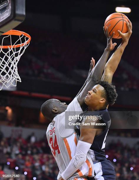 Cheikh Mbacke Diong of the UNLV Rebels blocks a dunk attempt from Dwayne Brown Jr. #25 of the Utah State Aggies during their game at the Thomas &...