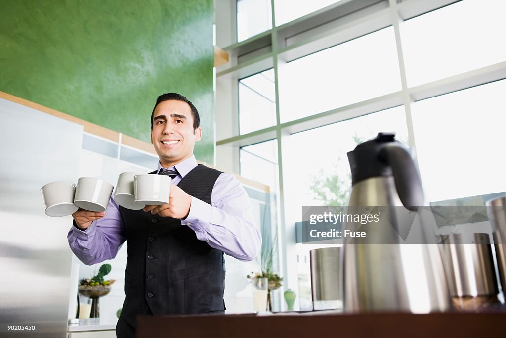 Businessman carrying several coffee cups