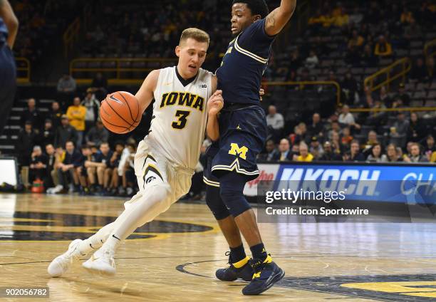 Iowa guard Jordan Bohannon tries to drive around Michigan guard Zavier Simpson in the second half during a Big Ten Conference basketball game between...