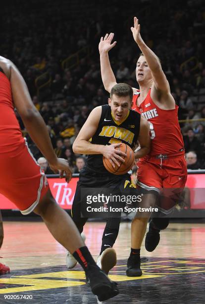 Iowa guard Jordan Bohannon drives past Ohio State guard Andrew Dakich during a Big Ten Conference basketball game between the Ohio State Buckeyes and...