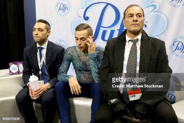 Adam Rippon waits for his score in the kiss and cry with his coaches Derrick Delmore and Rafael Arutunian after skating in the Men's Free Skate...