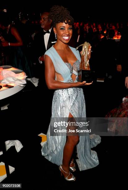 Shanola Hampton poses with the Visionary & Spirit of Elysium award at the Moet Hennessy John Legend's HEAVEN with the Art of Elysium at Barker Hangar...