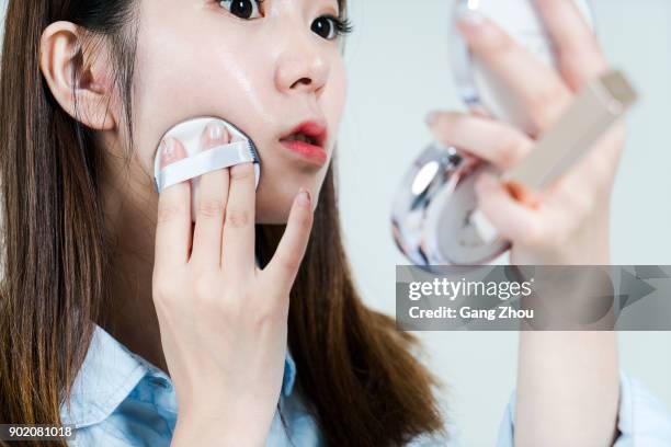 studio shot of young asian businesswoman applying makeup - powder puff stock pictures, royalty-free photos & images