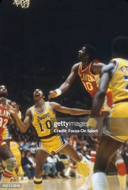 Tree Rollins of the Atlanta Hawks looks to grab a rebound over Norm Nixon of the Los Angeles Lakersa during an NBA basketball game circa 1980 at The...