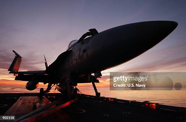 As the sun rises an F/A-18 "Hornet" is ready for the upcoming day of flight operations January 2, 2002 aboard the USS John C. Stennis in the Arabian...