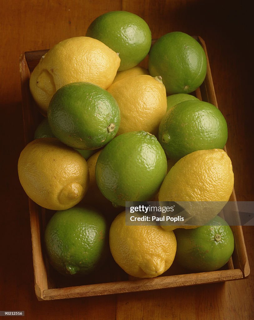 Limes and lemons in wooden tray